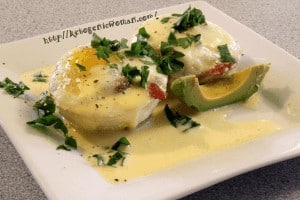 Keto Eggs Benedict garnished with parsley on white plate