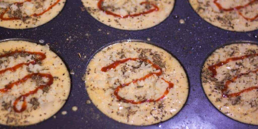 mini keto pizzas in the pan before baking