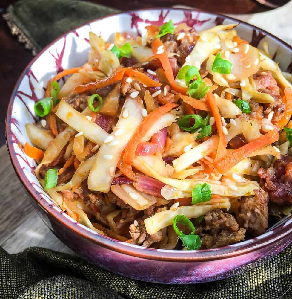A bowl of food, with Egg roll and Coleslaw