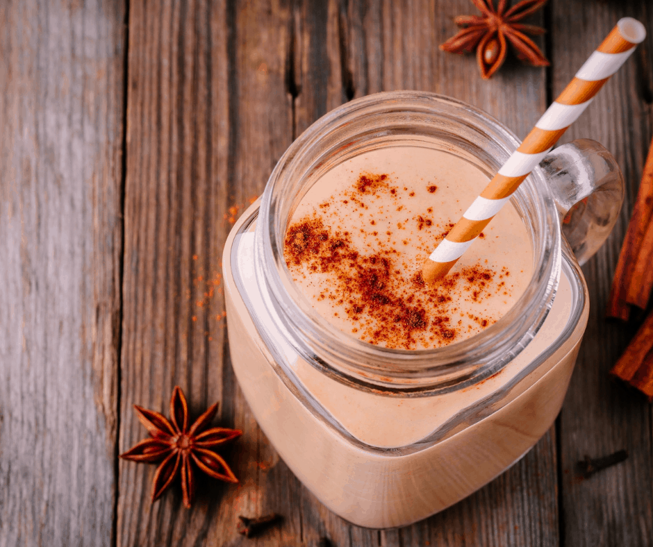 Pumpkin Spice shake topped with cinnamon on wooden board