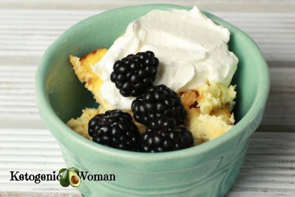 keto cheesecake topped with berries and whipped cream in blue bowl