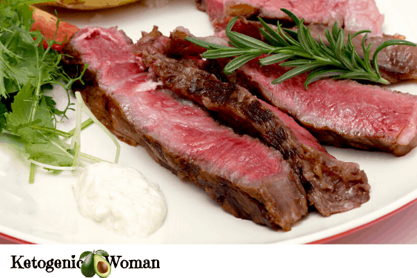 Sliced roast beef with horseradish sauce and greens on a plate
