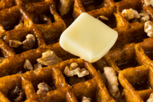 Keto Pumpkin Spice Waffles topped with butter and walnuts