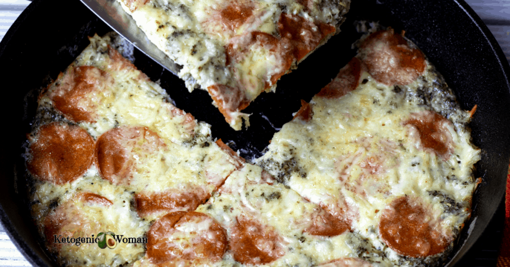 carnivore pepperoni pizza being lifted out of skillet
