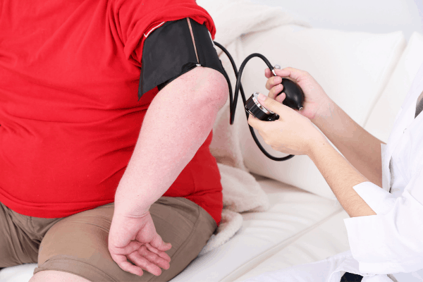 obese patient getting blood pressure checked