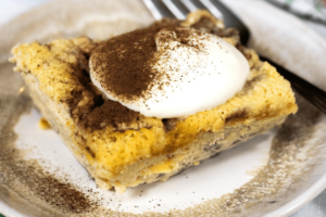 Keto Noodle Kugel garnished with whipped cream and cocoa on saucer